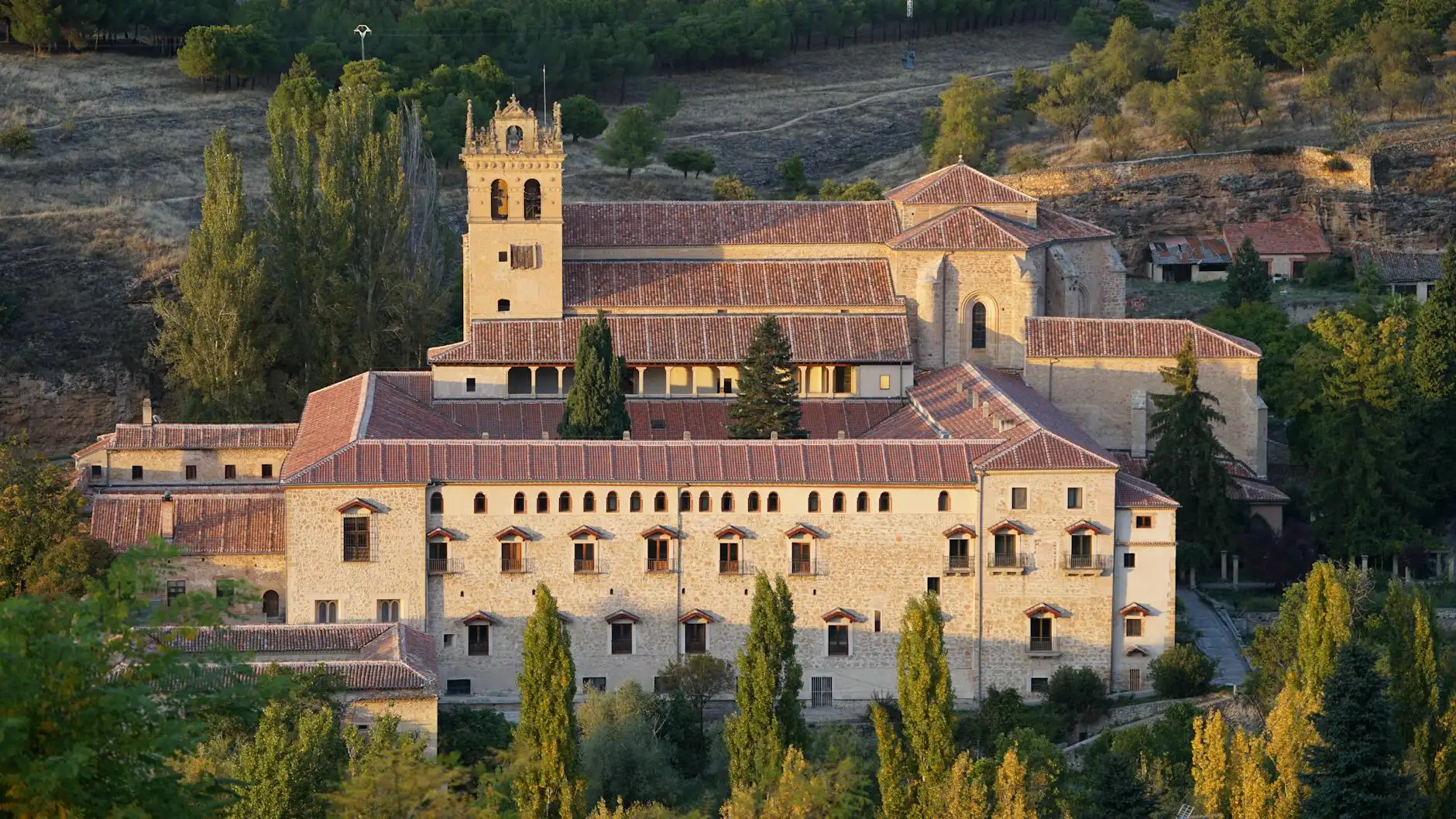 Beautiful view of a historic monastery in Segovia, Spain, surrounded by natural landscape.